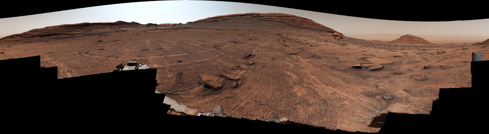 Curiosity panorama: Martian plain covered in polygonal honeycomb fractures toward distant hills