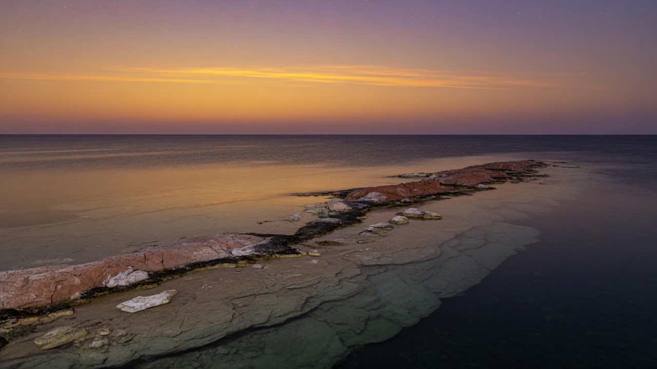 A drowned ridge just under a dusk sea